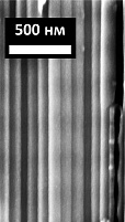 Изображение поперечного сечения микроструктуры фотонного кристалла. Фотонный кристалл состоит из трубок с одинаковым внешним диаметром. В правом нижнем углу видна рассечённая трубка, внутренний диаметр которой периодически изменяется